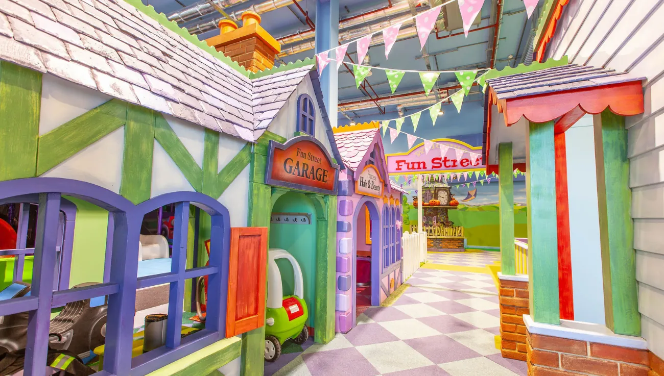 The full storybook street at Fun Street, bunting overhead and painted shopfronts down both sides